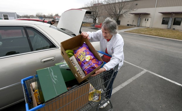 Eva Puhl loads her car with food while outside the Weld County Food Bank in Greeley March 10, 2023. The local food bank has seen an 83% increase in new families in the past year. (Jim Rydbom/Staff Photographer)